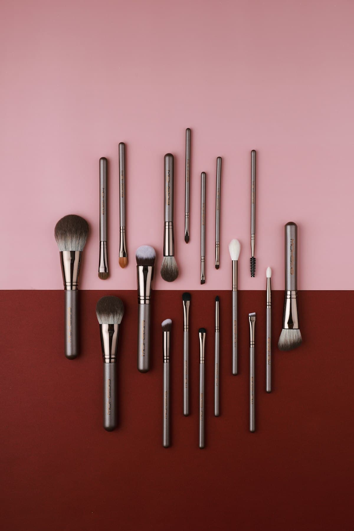 Makeup brushes laid out on blush and deep red